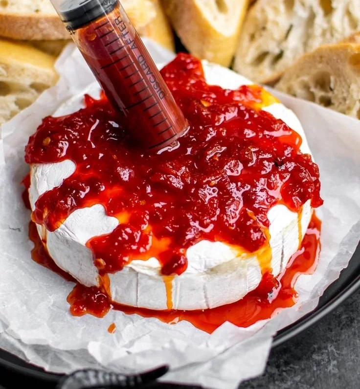 Delicious Bloody Baked Brie topped with vibrant ingredients