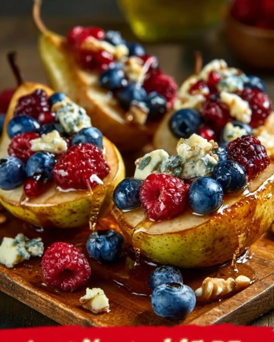 Baked pears topped with berries, honey, walnuts, and blue cheese in a dish.