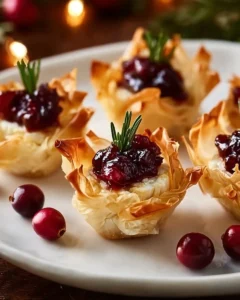 Gourmet cranberry and brie phyllo cups served on a platter.
